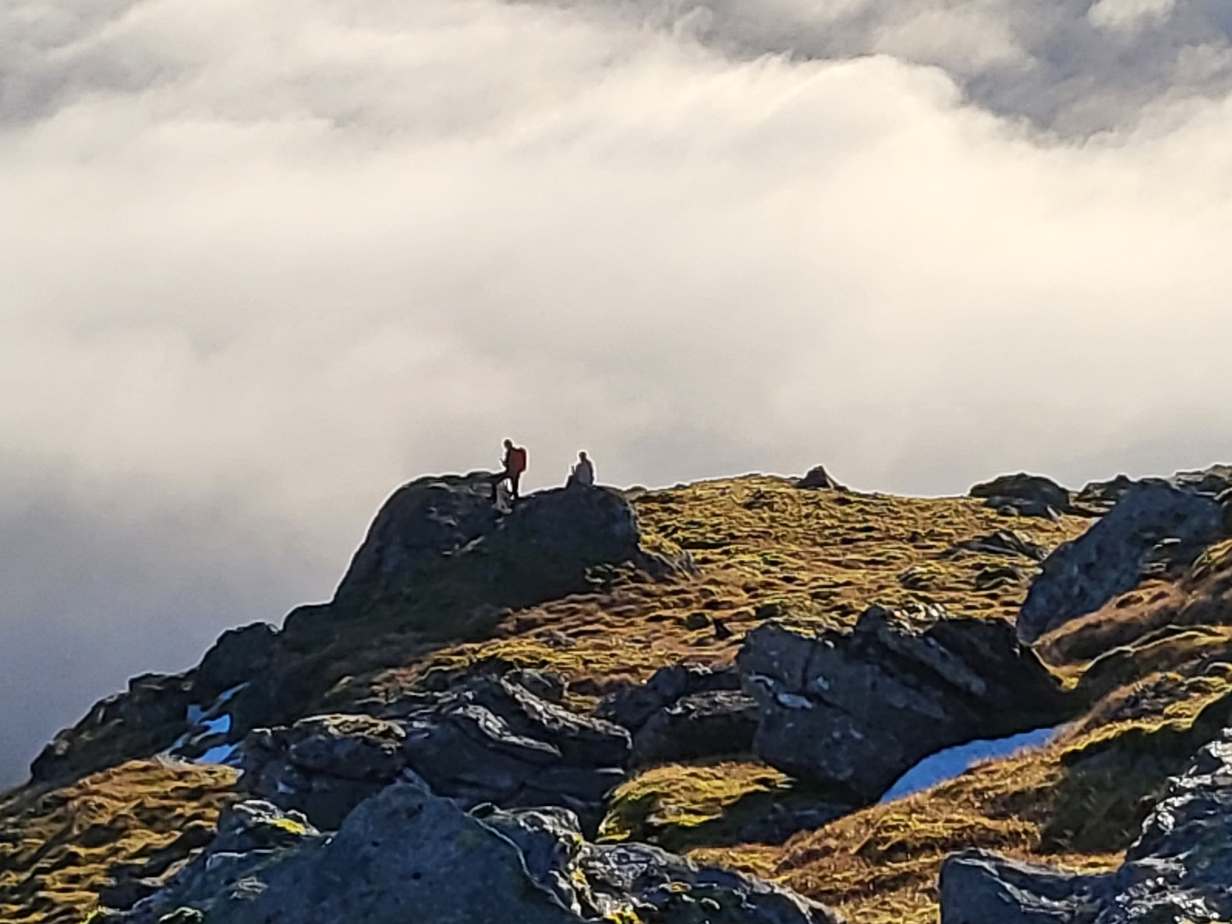 Paraglider looking over the clouds above the A82 in Scotland near the top of Beinn Dorian