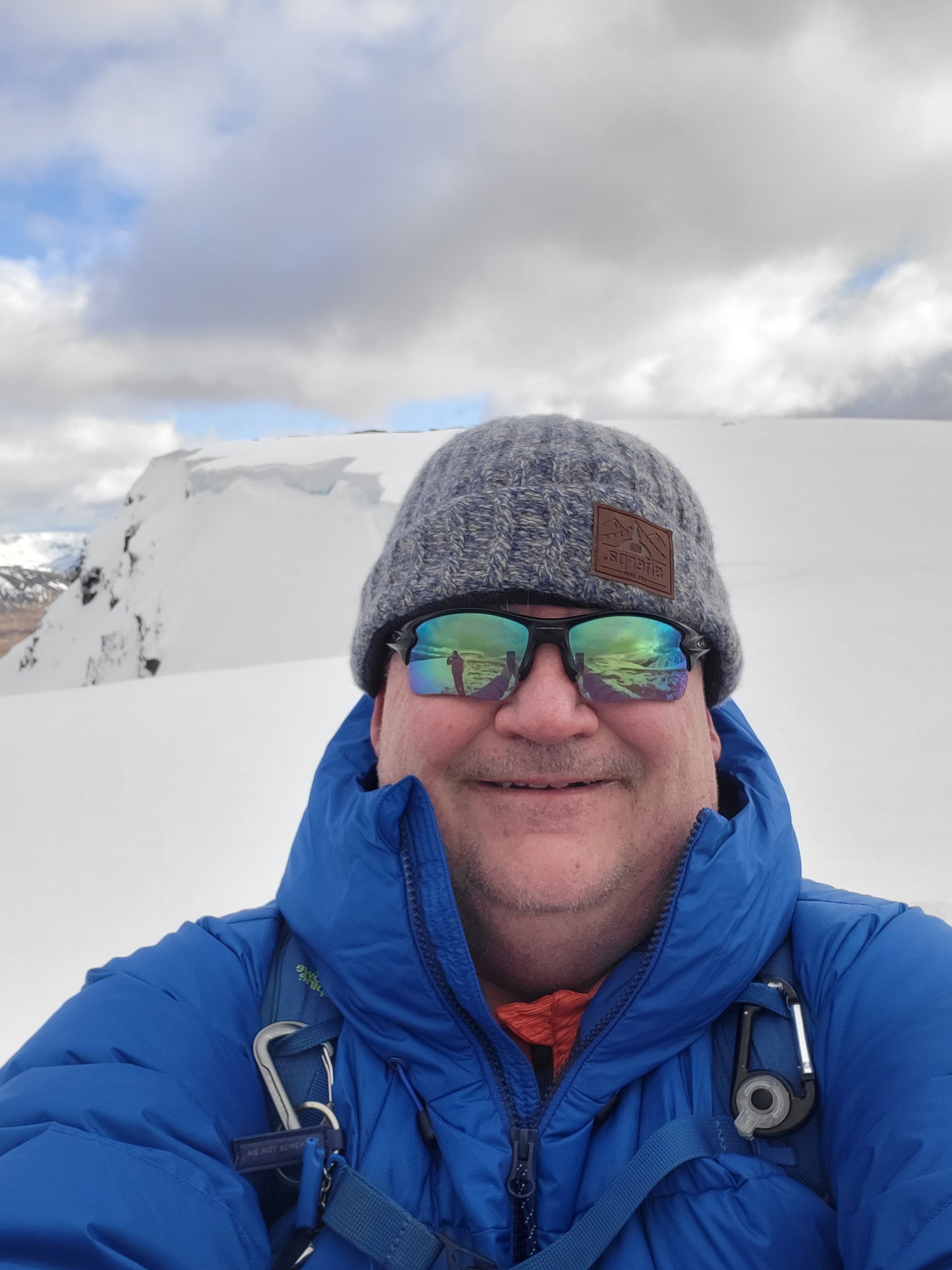 Sean McBride standing in front of a cornice on the summit of Beinn An Dothaidh