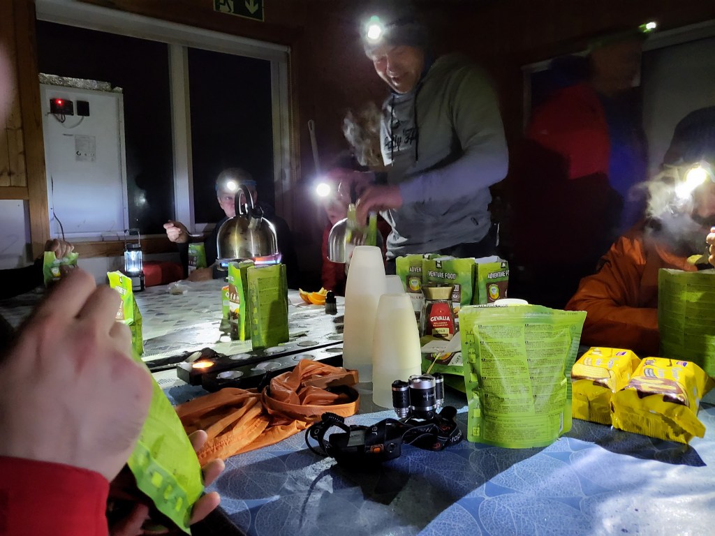People inside mountain hut having dinner.