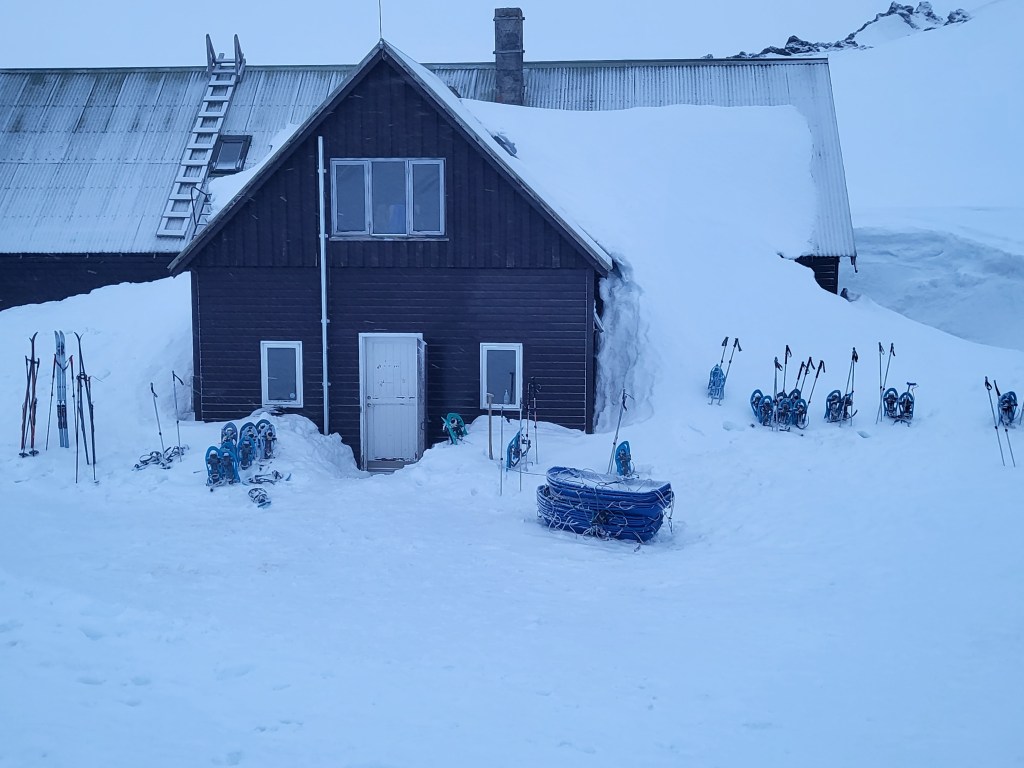 Mountain hut surrounded by deep snow.