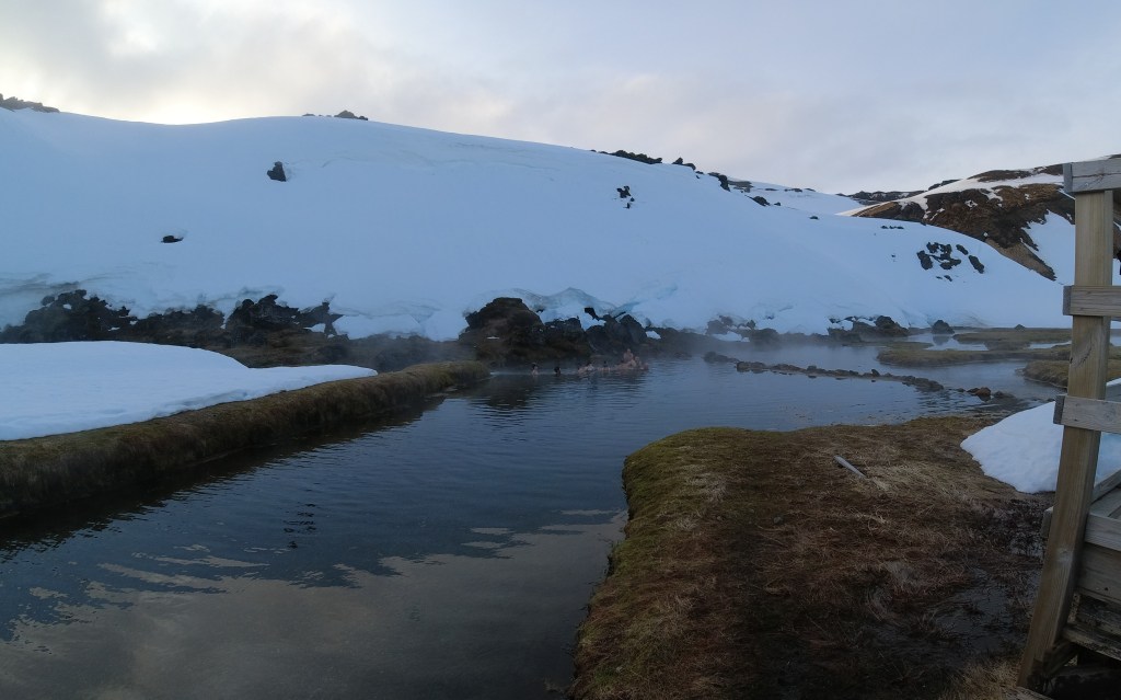 People bathing in a hot spring in the snow.