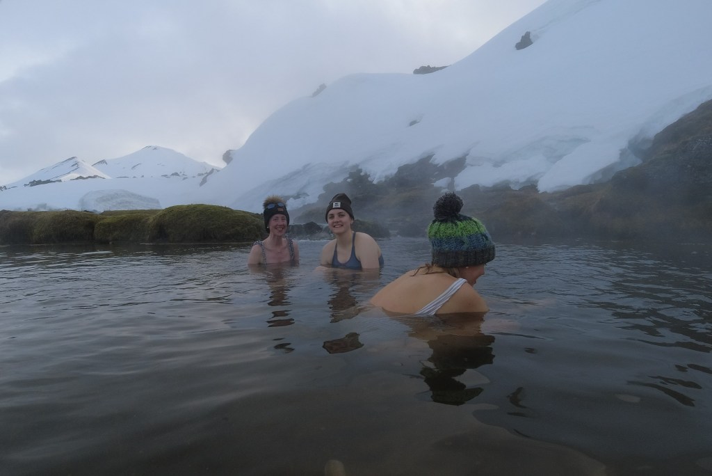 People bathing in a hot spring in the snow.