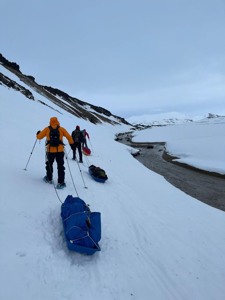 traversing a steep snow slope with Pulkas.