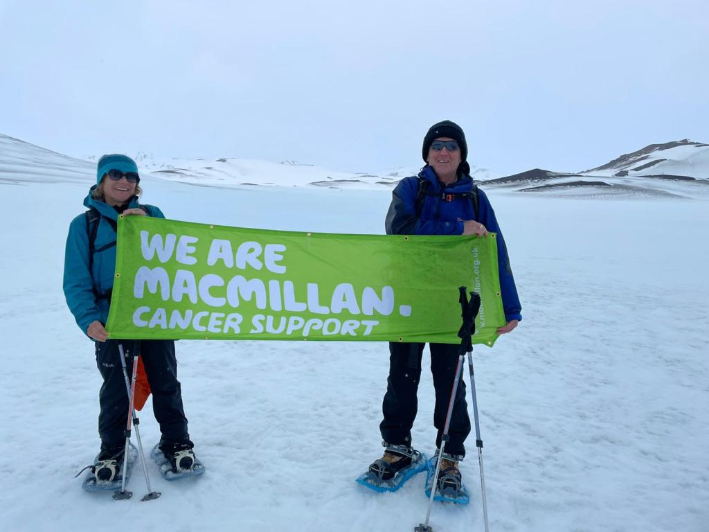 2 people holding up a banner for Macmillan Cancer Support.