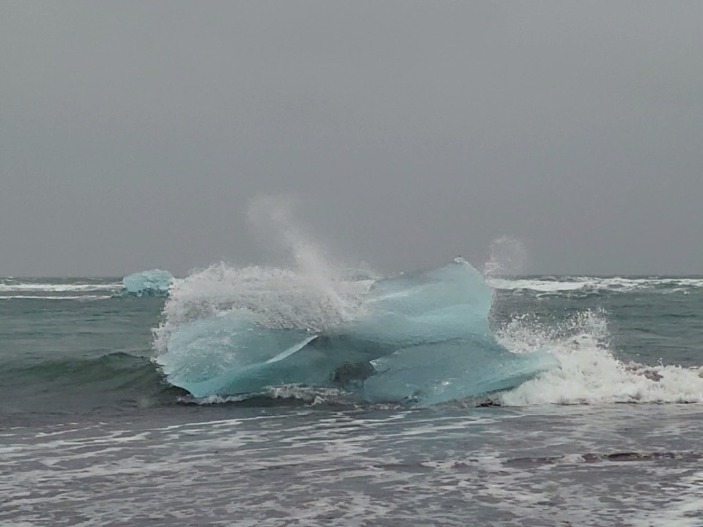 Waves break over a chunk of ice